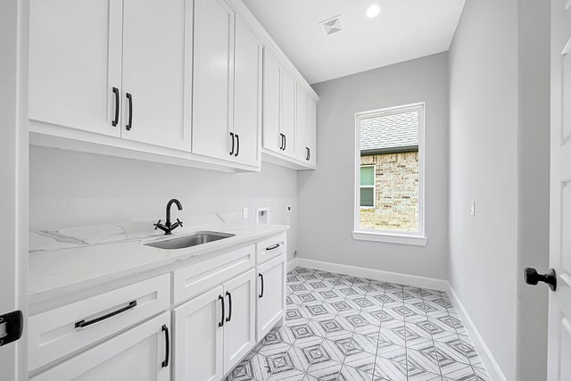 clothes washing area featuring washer hookup, cabinets, sink, and electric dryer hookup