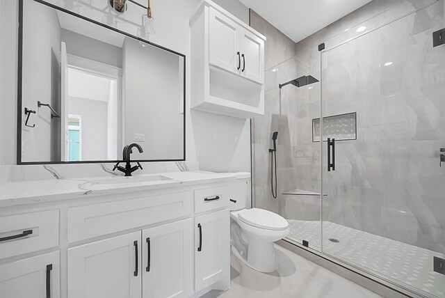 bathroom with vanity, a shower with door, and toilet