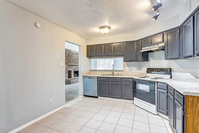 kitchen featuring light tile patterned floors, sink, dishwasher, a fireplace, and white range with electric stovetop