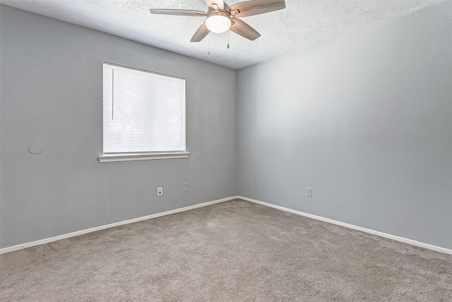 carpeted spare room with ceiling fan and a textured ceiling