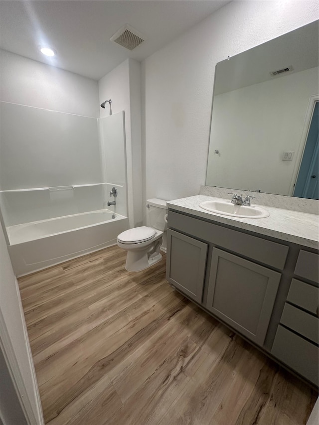 full bathroom with shower / bathing tub combination, vanity, toilet, and hardwood / wood-style flooring