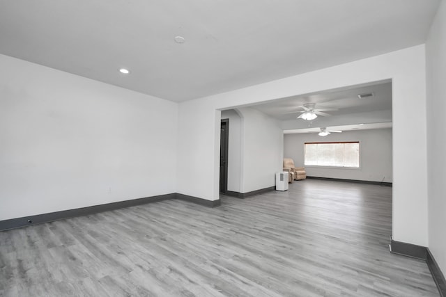 spare room with ceiling fan and light wood-type flooring