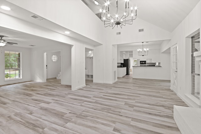 unfurnished living room with light hardwood / wood-style floors, vaulted ceiling, and ceiling fan