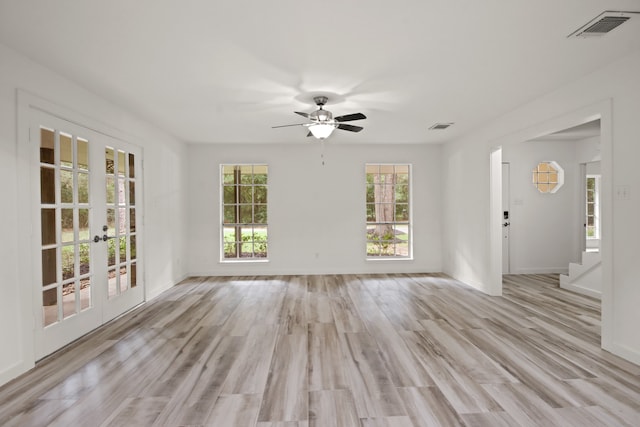 empty room with french doors, light hardwood / wood-style floors, and ceiling fan