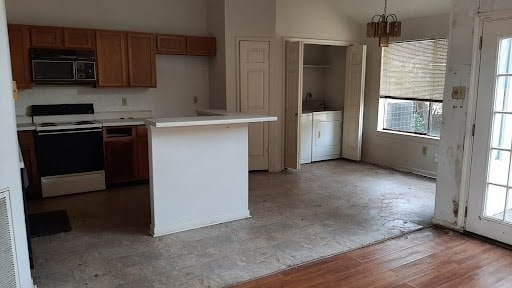 kitchen with built in microwave, a healthy amount of sunlight, light hardwood / wood-style floors, and electric range