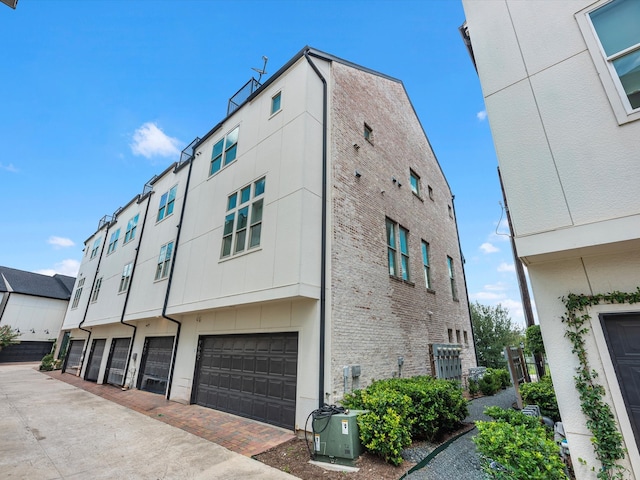 view of side of home with a garage and central AC