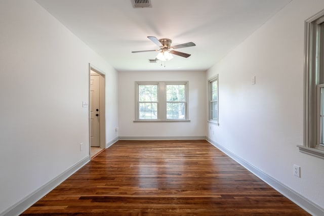 empty room with ceiling fan and dark hardwood / wood-style flooring