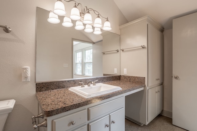 bathroom featuring vanity, lofted ceiling, and toilet