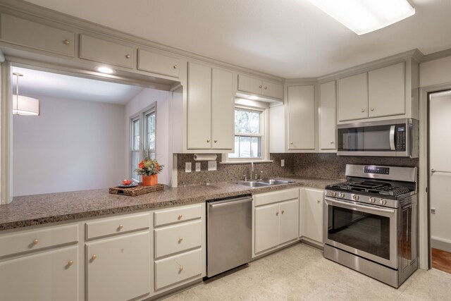 kitchen with appliances with stainless steel finishes, sink, and backsplash