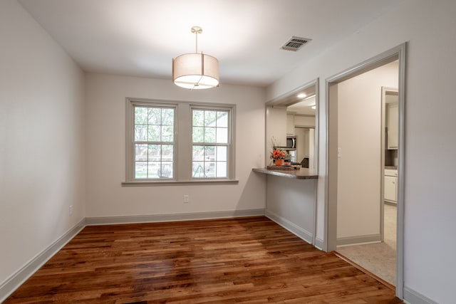 unfurnished dining area with dark hardwood / wood-style flooring