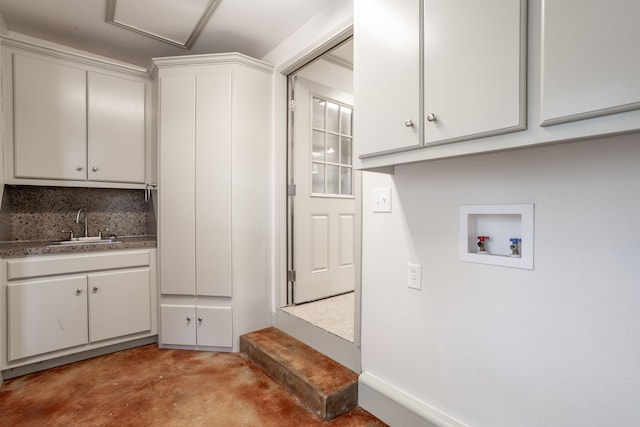 clothes washing area featuring cabinets, hookup for a washing machine, and sink