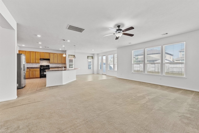 unfurnished living room with ceiling fan and light carpet