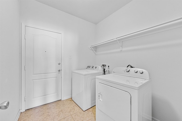 washroom with separate washer and dryer and light tile patterned flooring