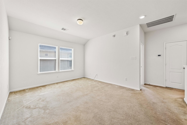 carpeted empty room featuring vaulted ceiling