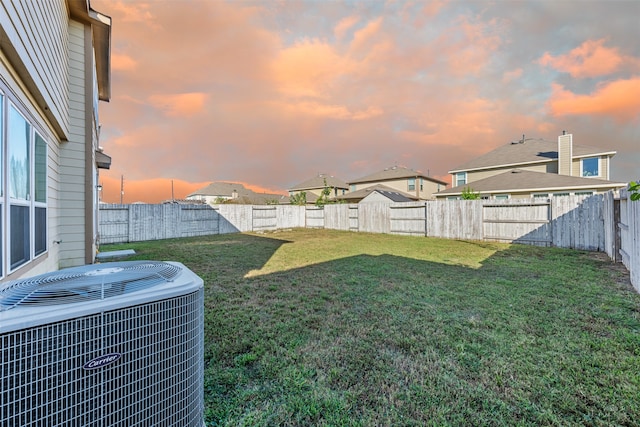 yard at dusk with central air condition unit