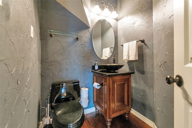 bathroom with hardwood / wood-style floors, vanity, and toilet