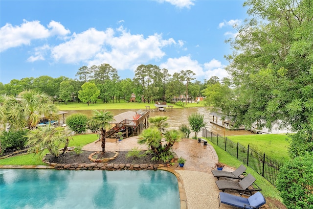 view of swimming pool with a water view and a yard