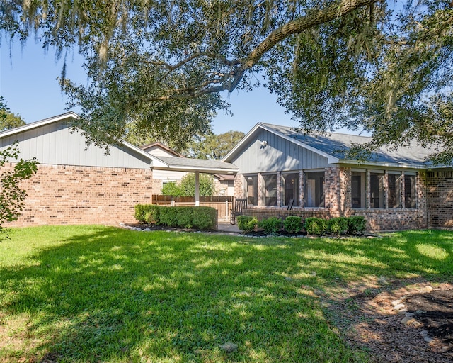 rear view of property with a sunroom and a yard