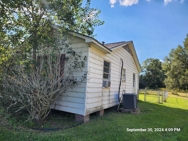 view of property exterior featuring cooling unit, central AC unit, and a lawn