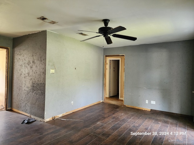 empty room with ceiling fan and dark hardwood / wood-style flooring