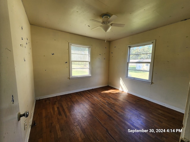 unfurnished room with dark wood-type flooring, a wealth of natural light, and ceiling fan