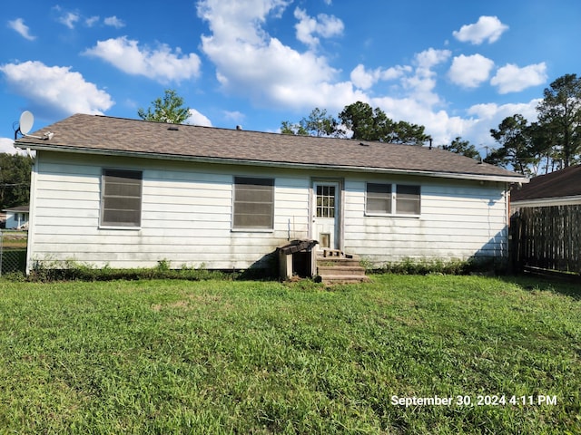 rear view of property featuring a yard