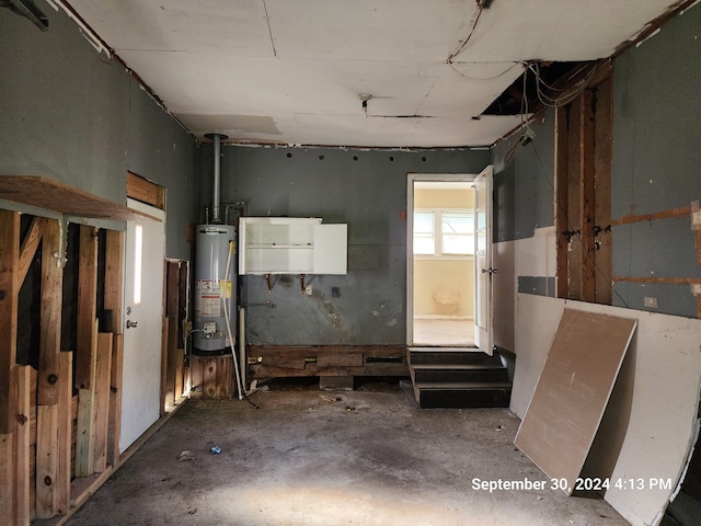 miscellaneous room featuring water heater and concrete floors