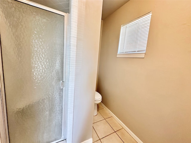 bathroom with tile patterned flooring, a shower with door, and toilet