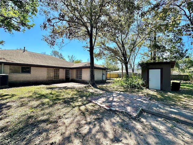 view of side of home featuring an outbuilding, central air condition unit, a patio, and a yard