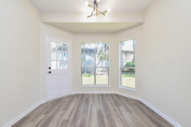 interior space with light hardwood / wood-style floors, plenty of natural light, and a notable chandelier