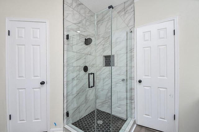 bathroom featuring hardwood / wood-style floors and a shower with shower door