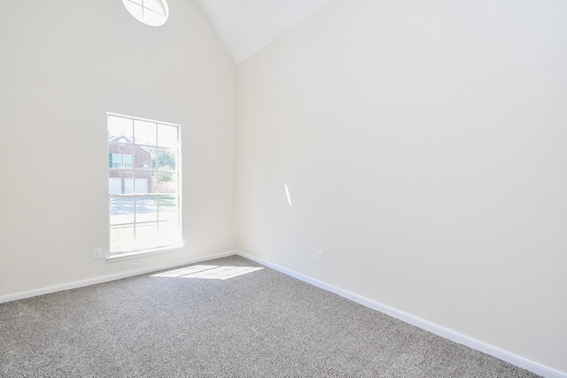 carpeted empty room featuring high vaulted ceiling