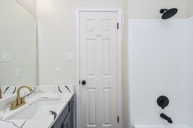 bathroom featuring vanity and tiled shower / bath