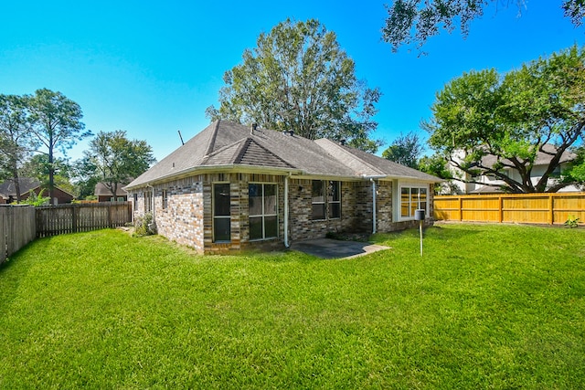 rear view of property featuring a lawn