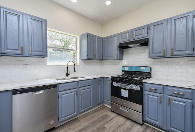 kitchen with hardwood / wood-style flooring, backsplash, sink, and stainless steel appliances