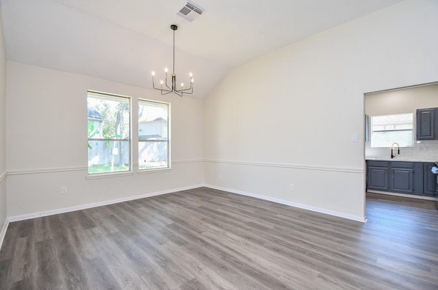 unfurnished room with an inviting chandelier, dark hardwood / wood-style flooring, sink, and vaulted ceiling