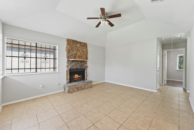 unfurnished living room with light tile patterned flooring, lofted ceiling, a fireplace, and ceiling fan