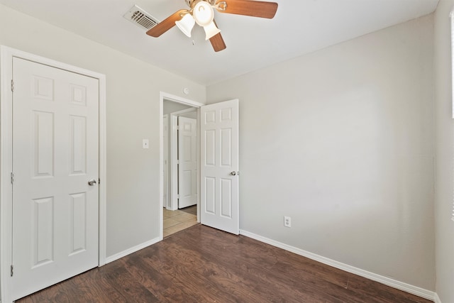 unfurnished bedroom featuring dark hardwood / wood-style flooring and ceiling fan