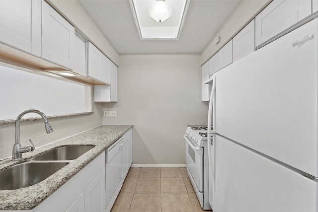 kitchen featuring white appliances, sink, light stone counters, and white cabinetry