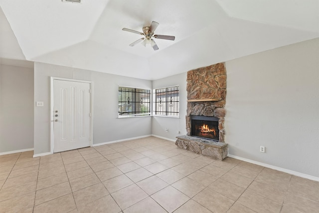 unfurnished living room featuring lofted ceiling, a fireplace, ceiling fan, and light tile patterned floors