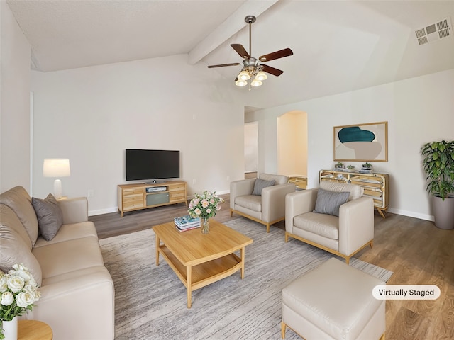 living room featuring hardwood / wood-style floors, vaulted ceiling with beams, and ceiling fan