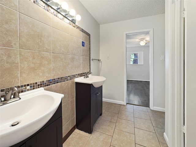 bathroom featuring tile patterned floors, ceiling fan, vanity, and a textured ceiling