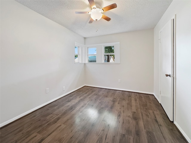 empty room featuring dark wood-type flooring, a textured ceiling, and ceiling fan