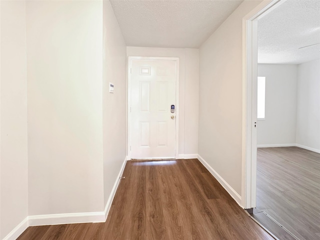602 Meadowglen Dr, Baytown, TX 77521 - hallway featuring a textured ceiling, baseboards, and dark wood-style floors