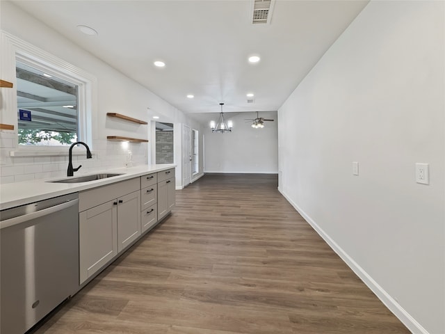 kitchen with tasteful backsplash, gray cabinetry, sink, dark hardwood / wood-style flooring, and dishwasher