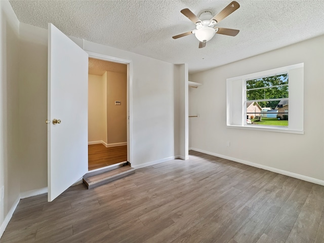 interior space featuring ceiling fan, hardwood / wood-style floors, and a textured ceiling