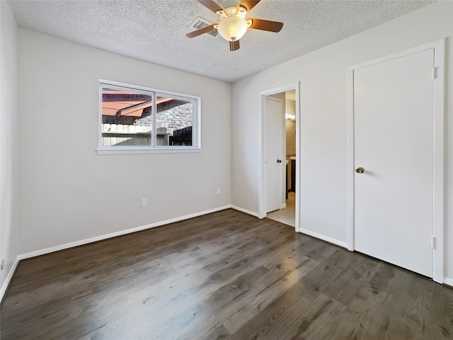 unfurnished bedroom with ceiling fan, a textured ceiling, and dark hardwood / wood-style floors