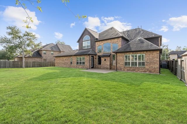 back of house with central AC, a patio area, and a lawn