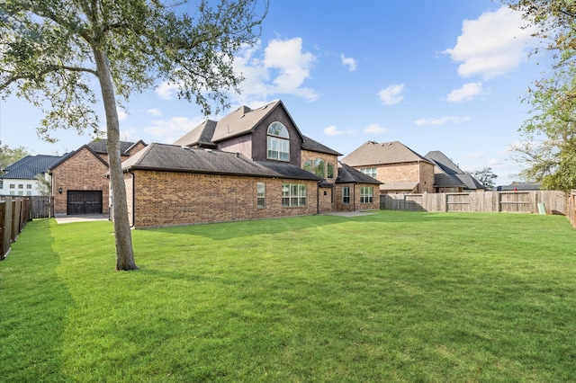 back of house featuring a garage and a lawn