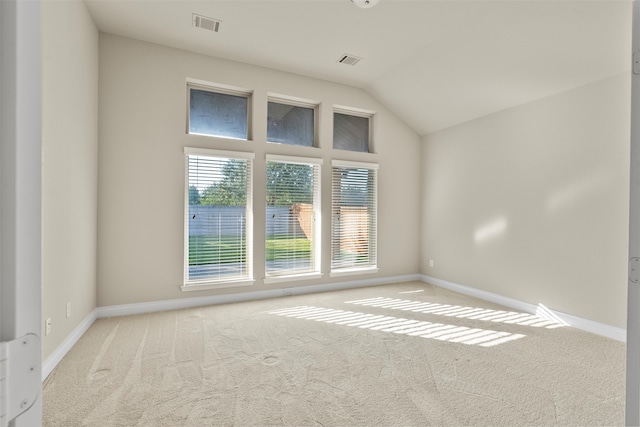 carpeted spare room with lofted ceiling